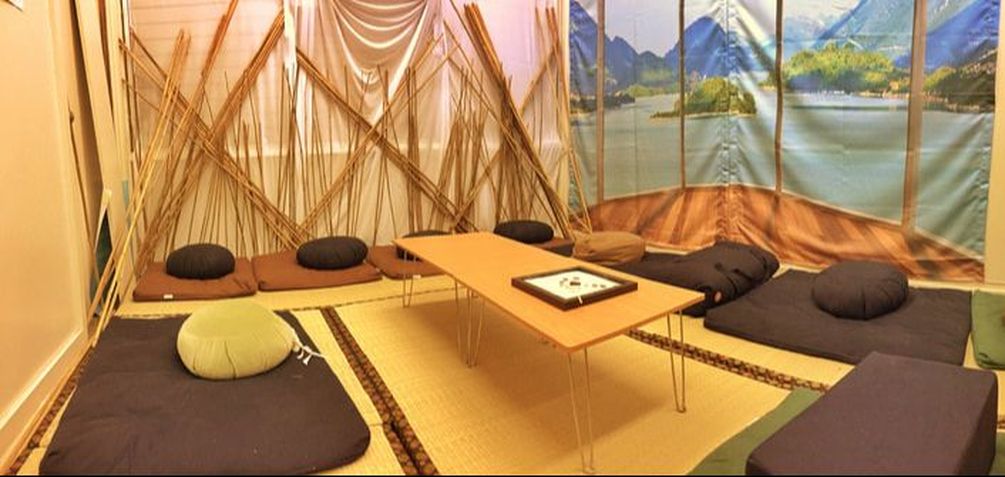 Relaxation room with soft mats and pillows surrounding a table.